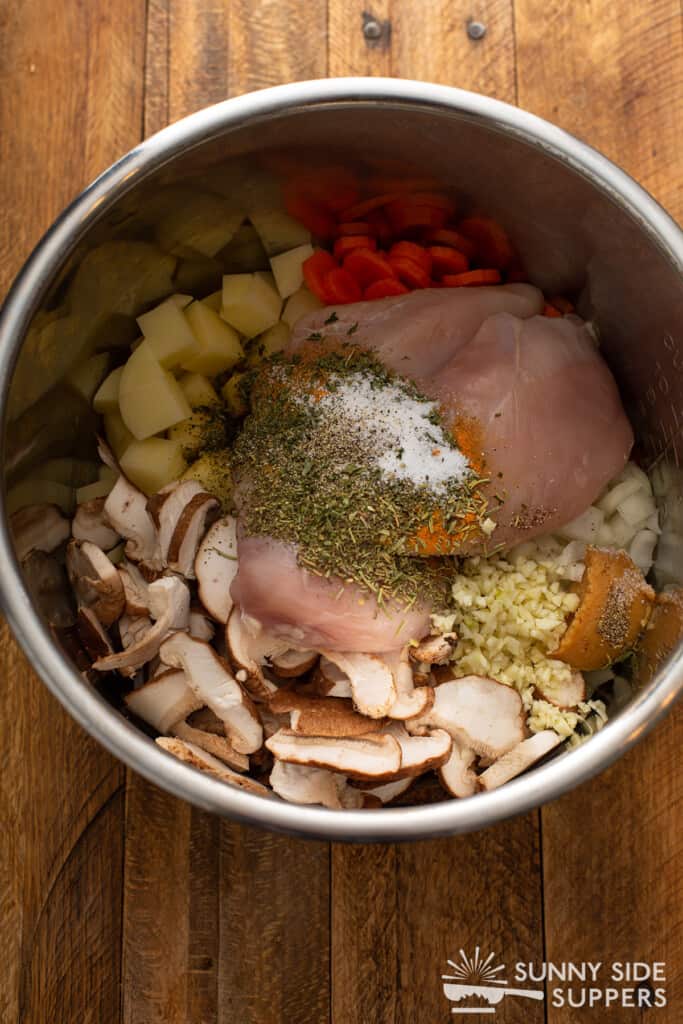 An instant pot bowl filled with chicken soup ingredients.